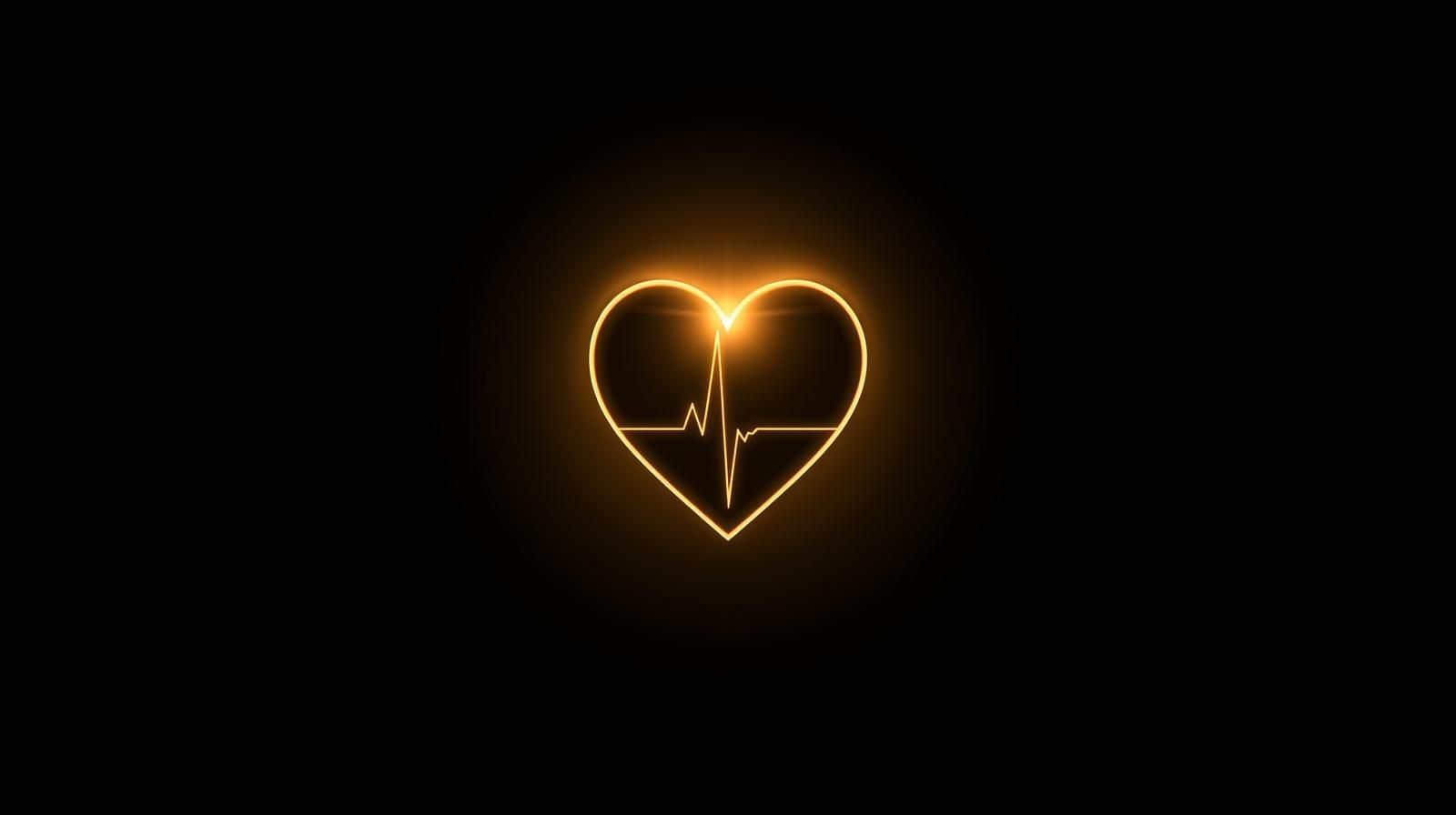 Glowing orange heart with animated heartbeat line on a black background.