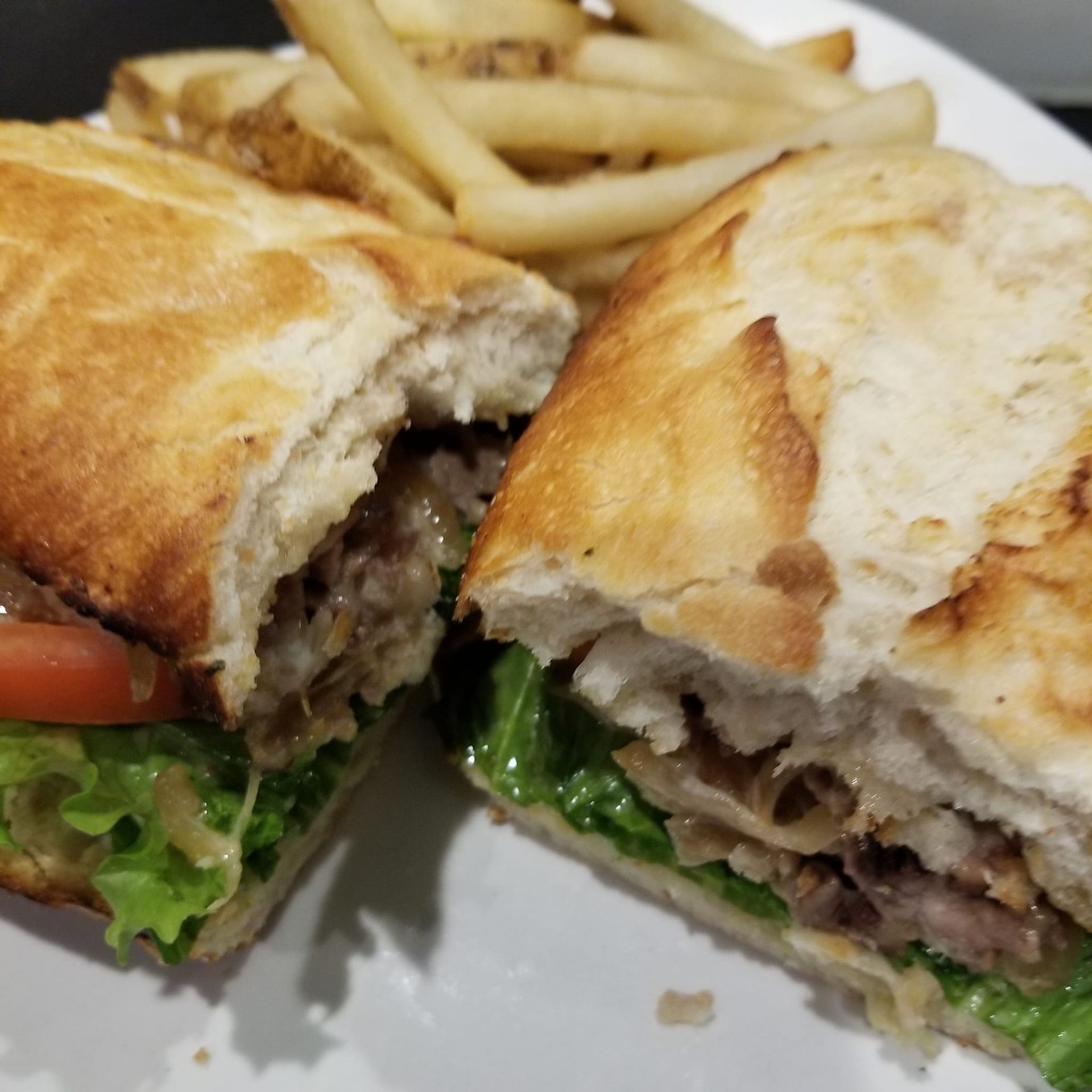 A sandwich and french fries on a white plate