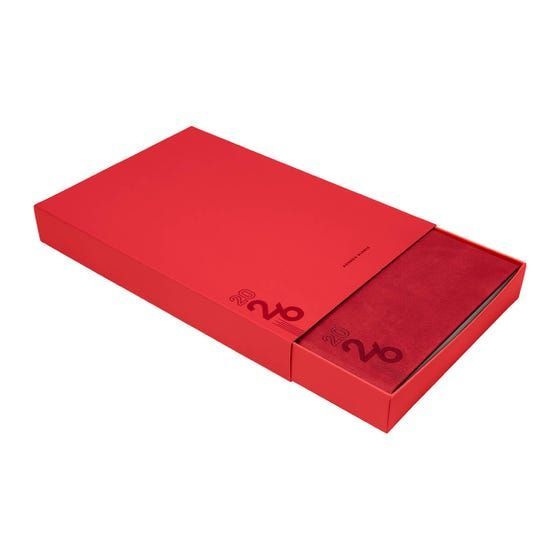 Una caja rectangular roja con cierre deslizante, que presenta un logotipo minimalista en relieve y que se abre parcialmente para revelar un interior rojo a juego.