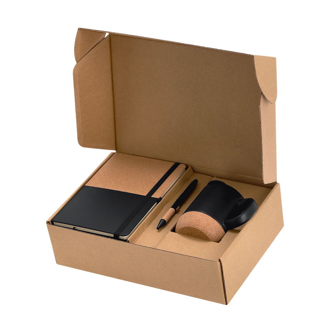 Un set de regalo en una caja de cartón marrón que contiene una libreta negra y de corcho, un bolígrafo a juego y una taza negra y de corcho.