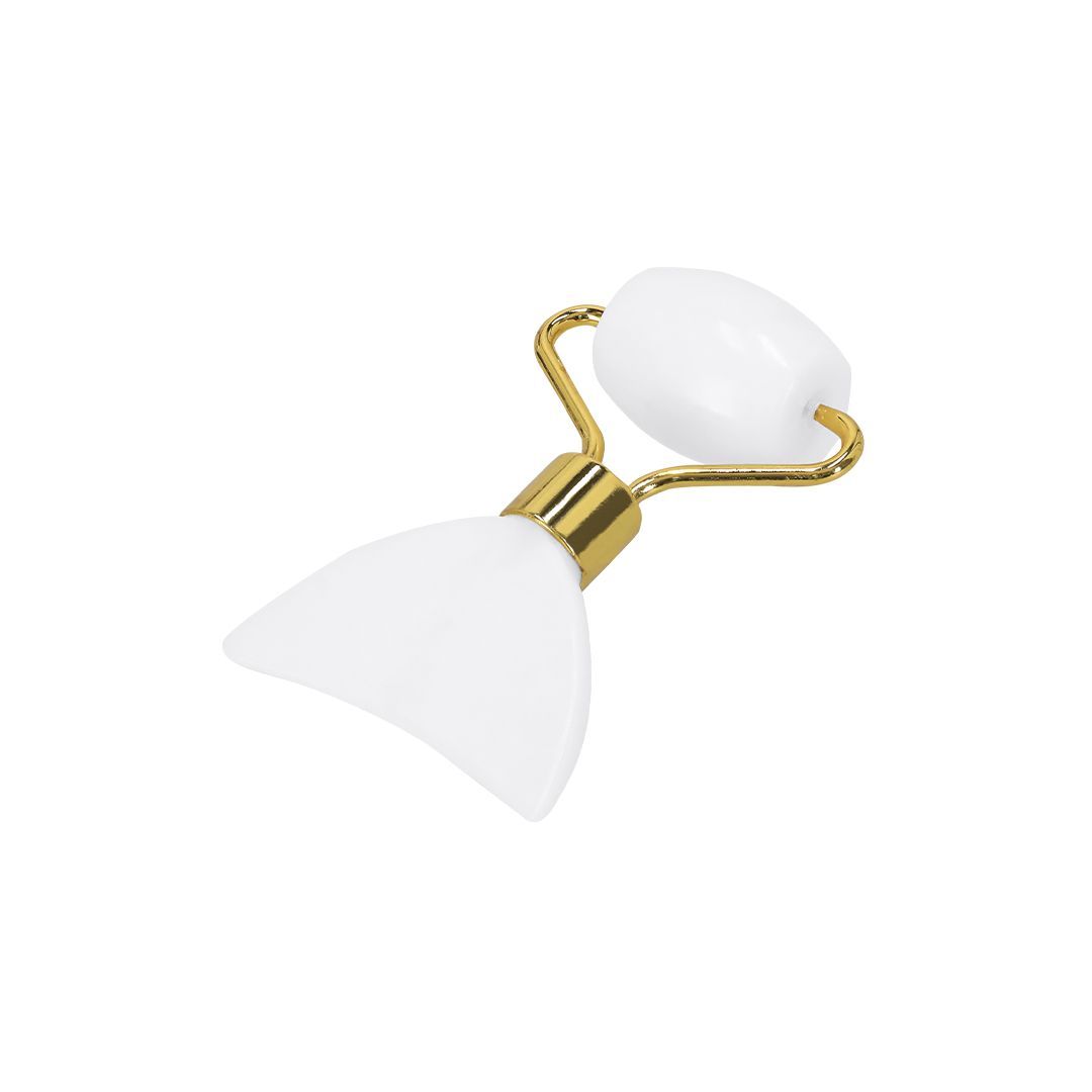 Un instrumento blanco para masajes faciales con un rodillo en un extremo y una piedra gua sha curva en el otro, unidos por una pieza de metal dorado.
