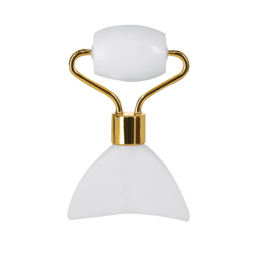 Un rodillo facial de jade blanco con mango de metal color oro, que cuenta con un rodillo cilíndrico y una base de placa curvada.