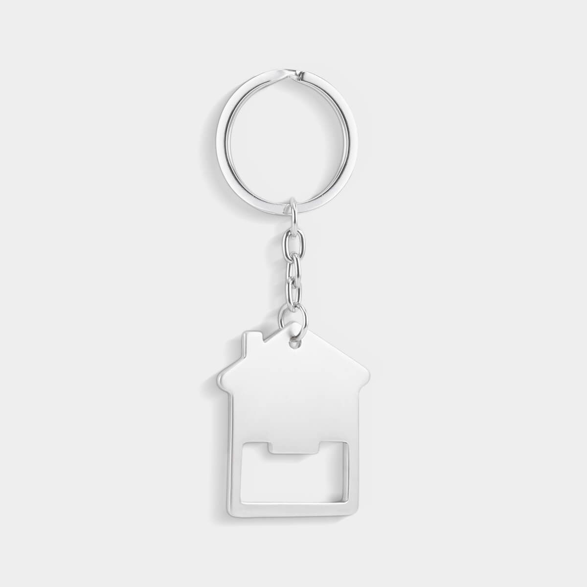 Llavero de metal plateado con forma de casa, con abridor de botellas incorporado y sujeto a una anilla circular.