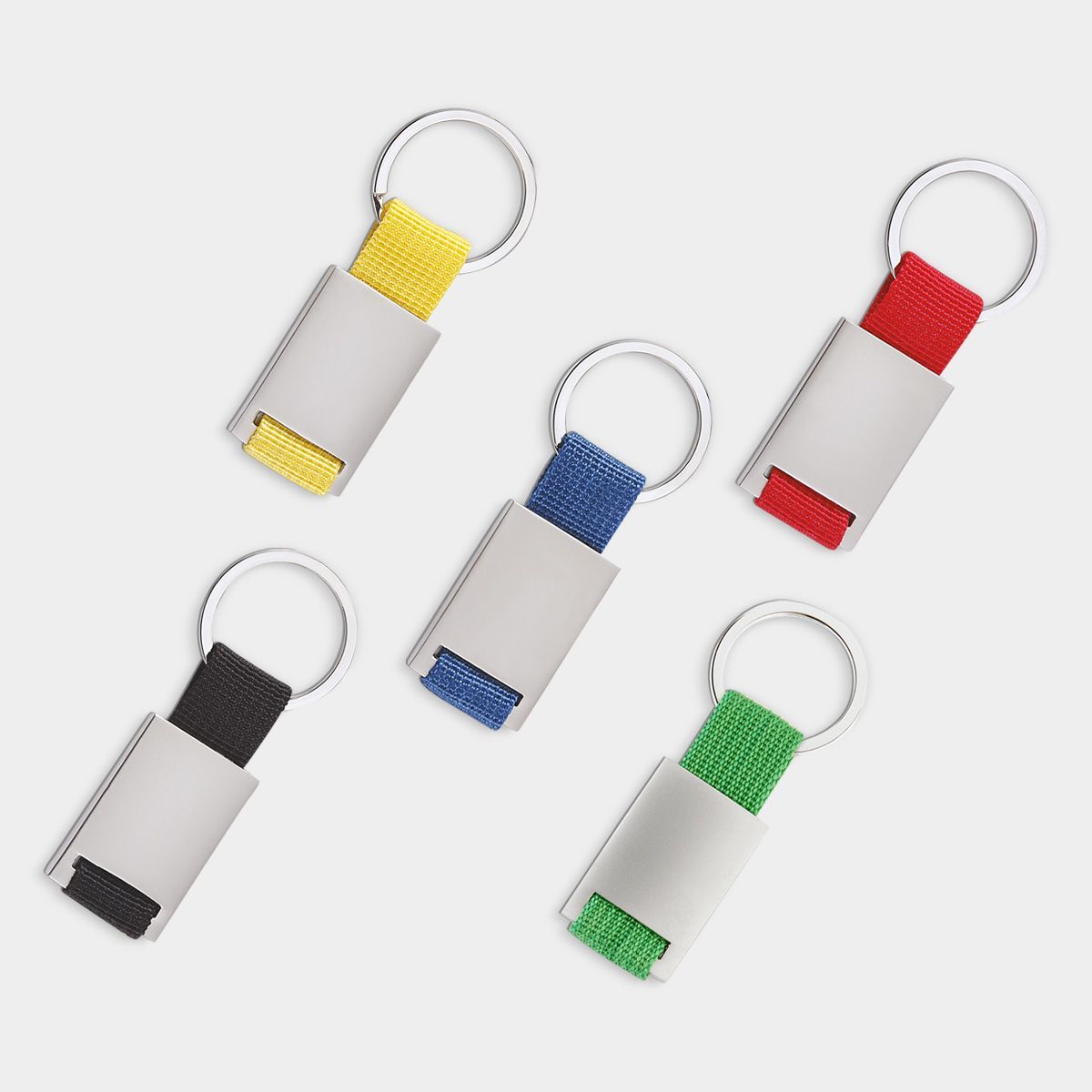 Cinco llaveros con placas rectangulares de metal plateado y correas de tela de colores amarillo, rojo, azul, verde y negro.