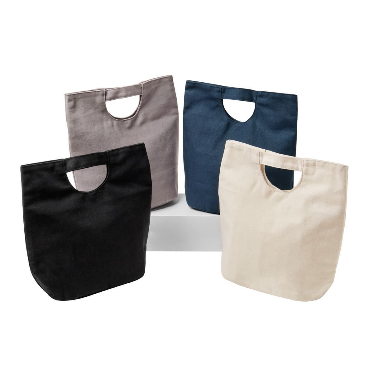 Cuatro bolsas de lona para el almuerzo en color negro, gris, azul oscuro y crema, dispuestas sobre una superficie blanca.
