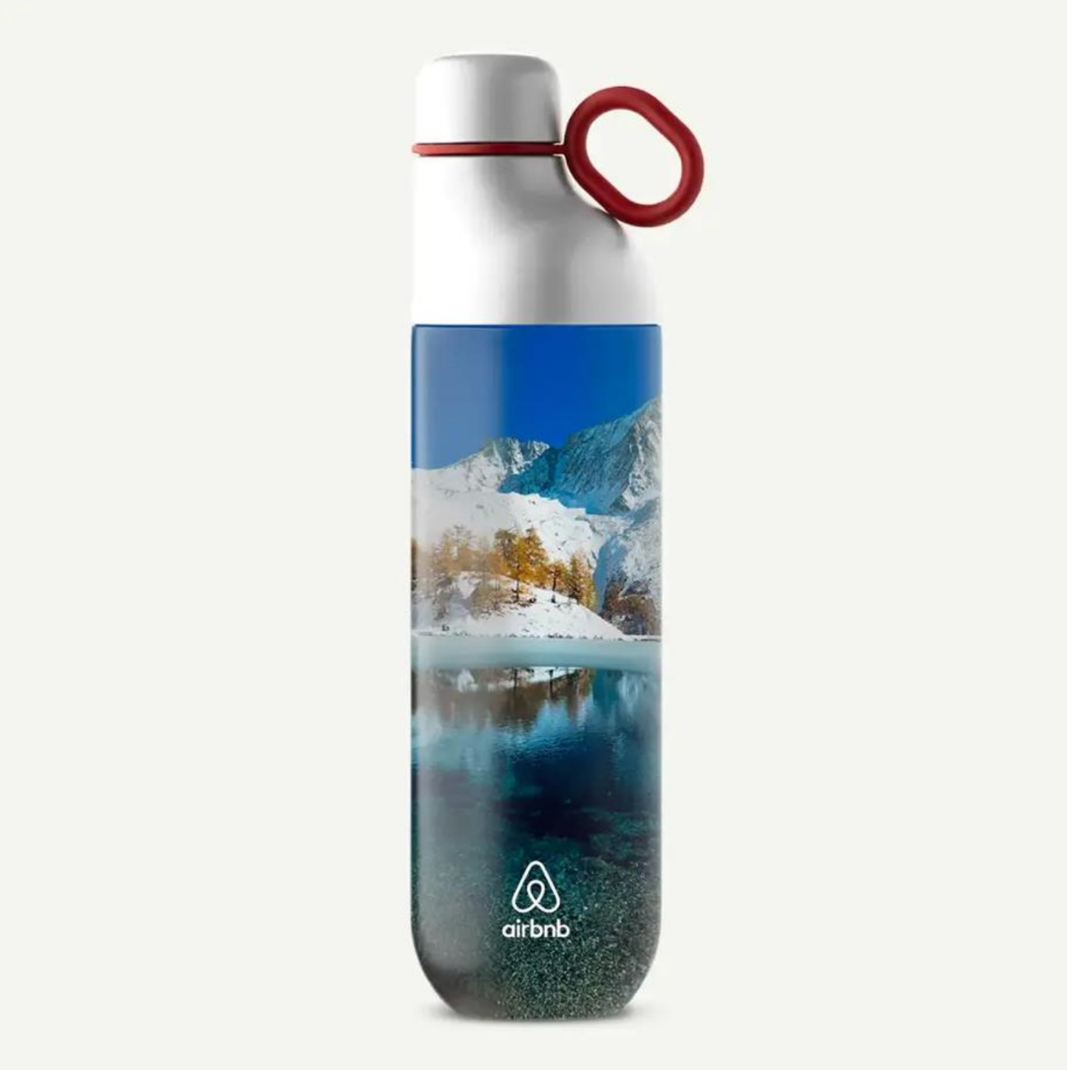Una botella de agua blanca reutilizable con tapón de anilla roja, que muestra un paisaje de un lago de montaña nevado y el logotipo de Airbnb.