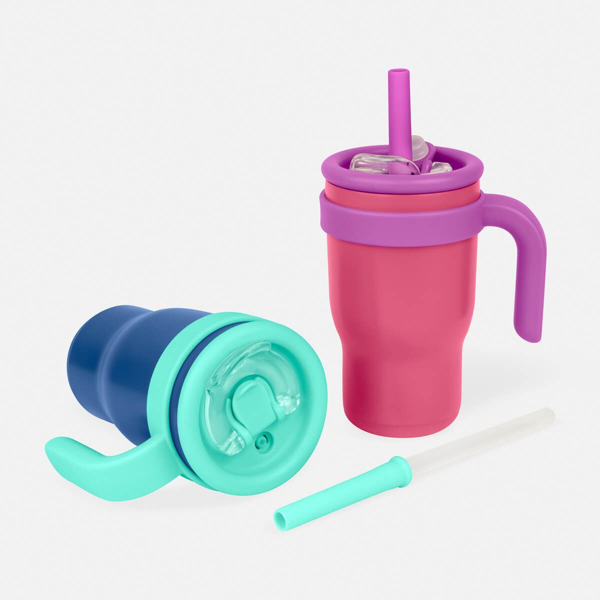 Dos tazas térmicas de colores con asa, una en posición vertical con pajita y la otra tumbada, sobre un fondo blanco liso.