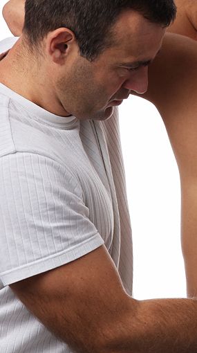 A man in a white shirt is massaging a man.