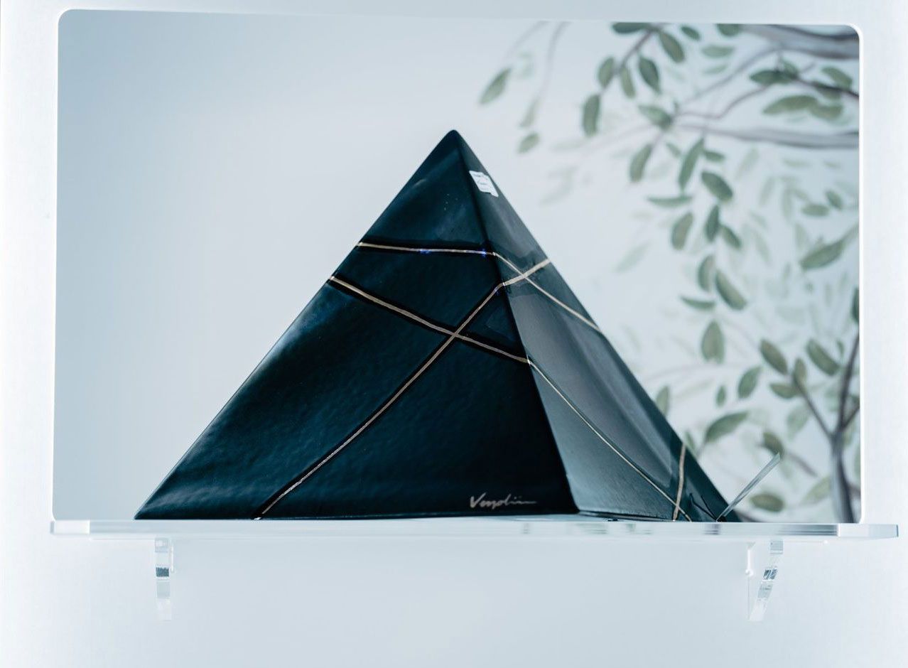 Un'immagine di una piramide con un albero sullo sfondo