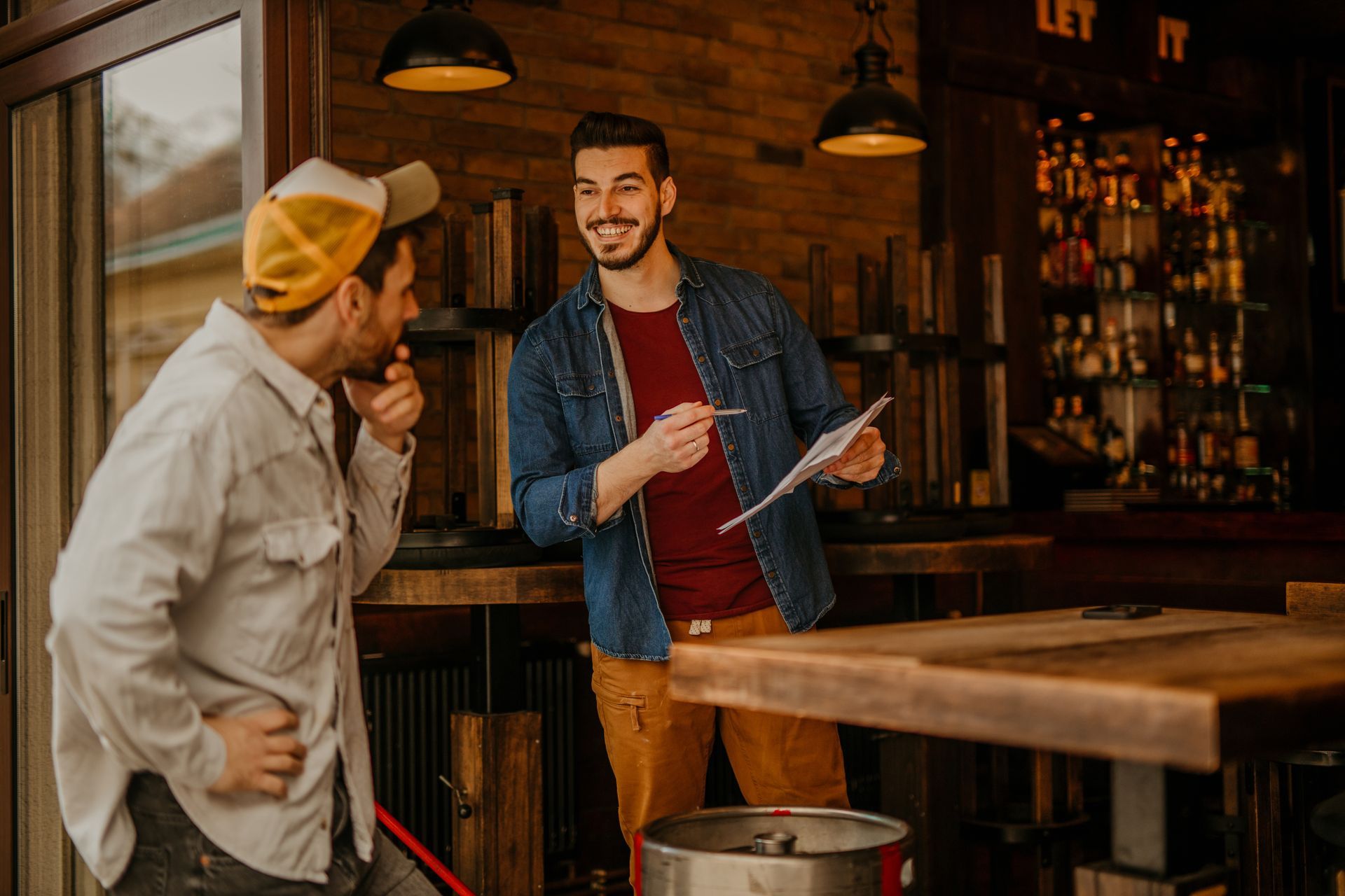 Chefs working in a busy commercial kitchen, cooking on the stove with steam rising.