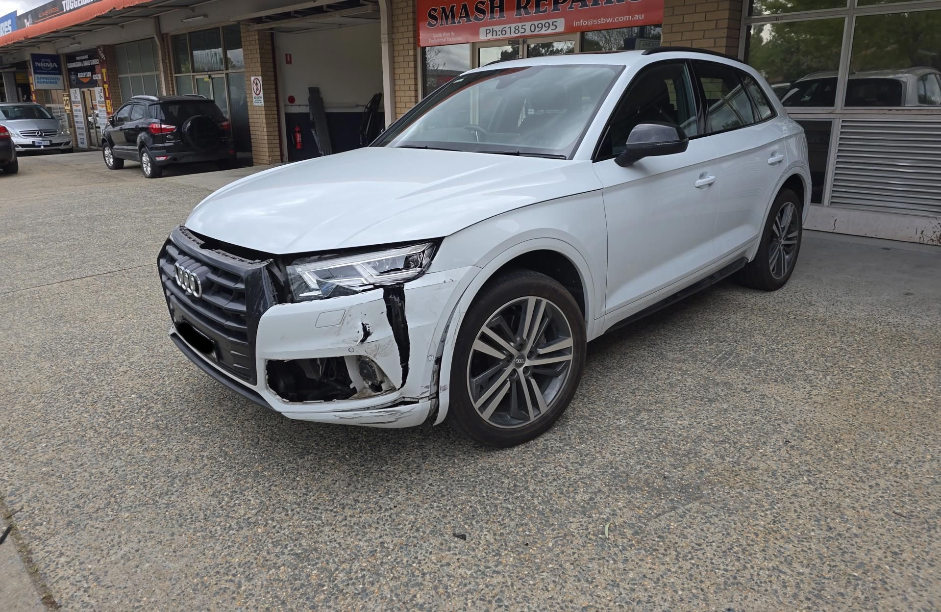 A white Audi Q5 is parked in front of a car dealership — Southside Bodyworks in Greenway, ACT