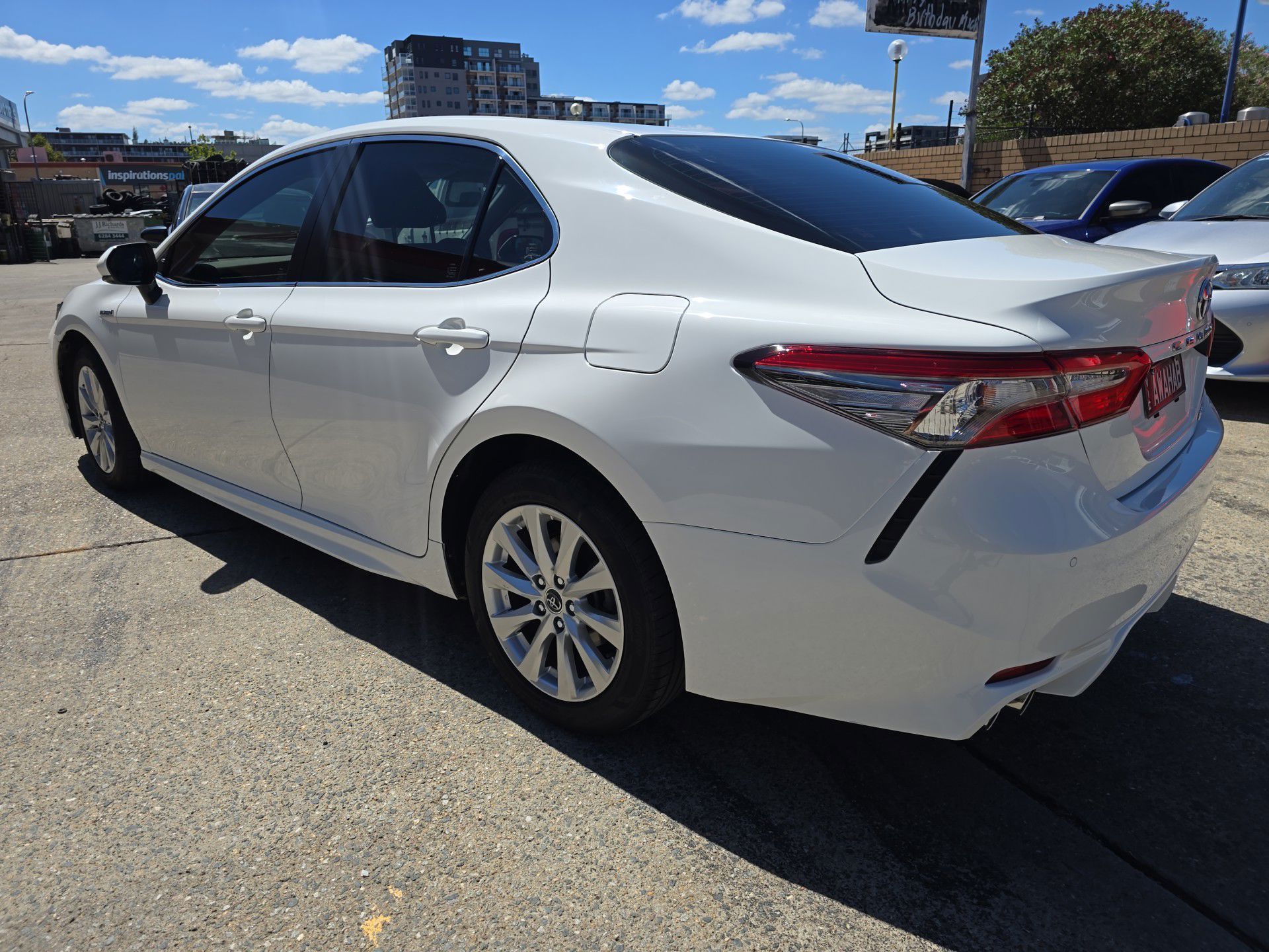 A white Toyota Camry is parked in a parking lot — Southside Bodyworks in Greenway, ACT