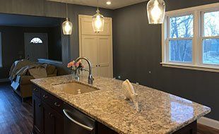 A kitchen with a large granite counter top and a sink.