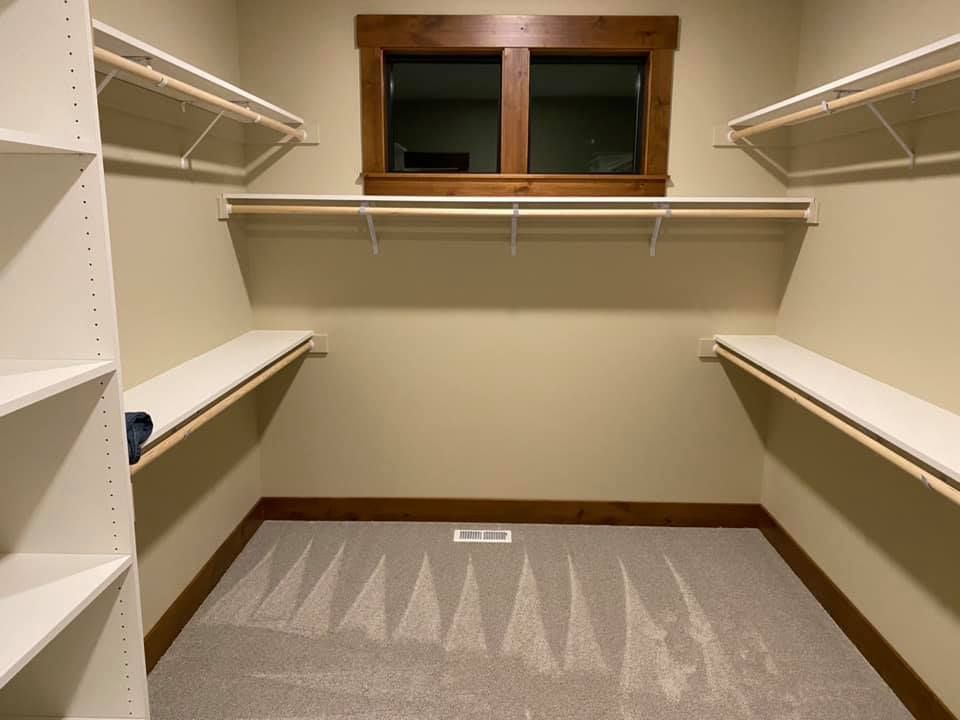 A walk in closet with shelves and a window