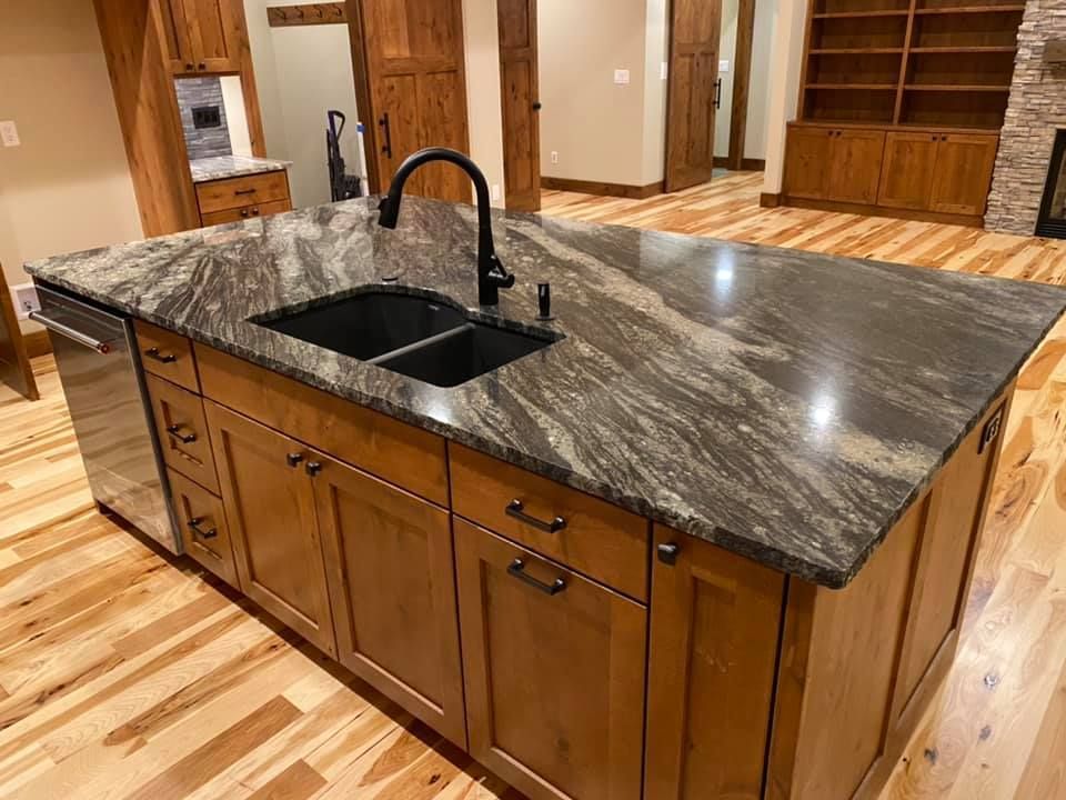 A kitchen with a large island and two sinks.