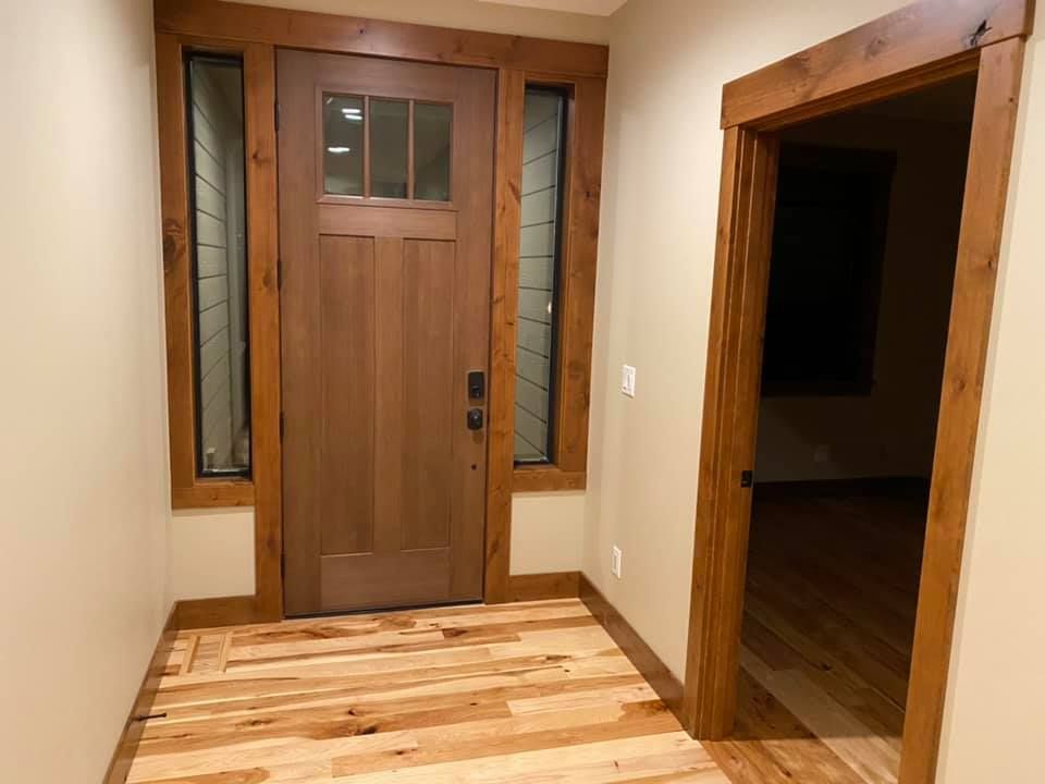 A hallway with a wooden floor and a wooden door