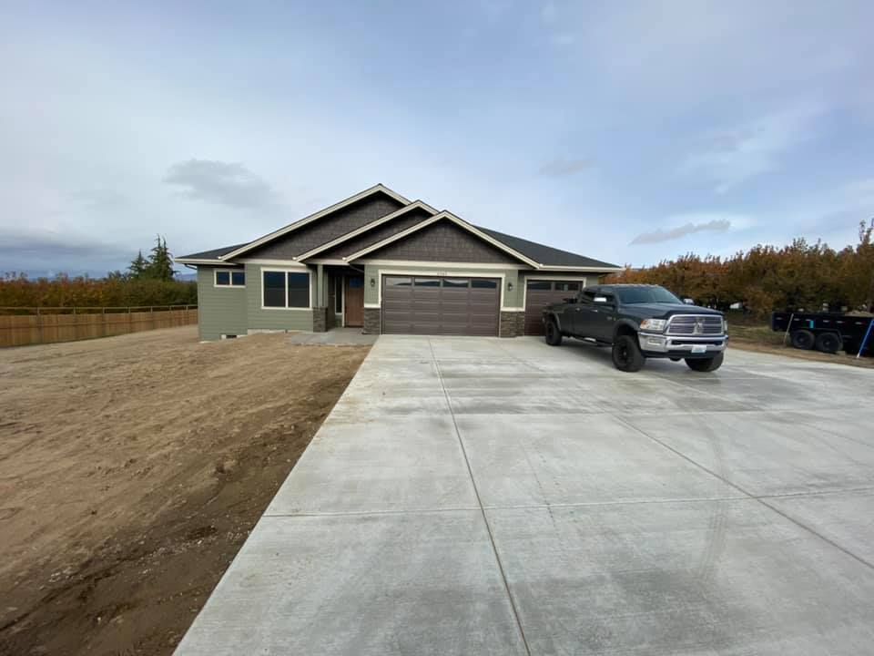 A truck is parked in front of a house in a driveway.