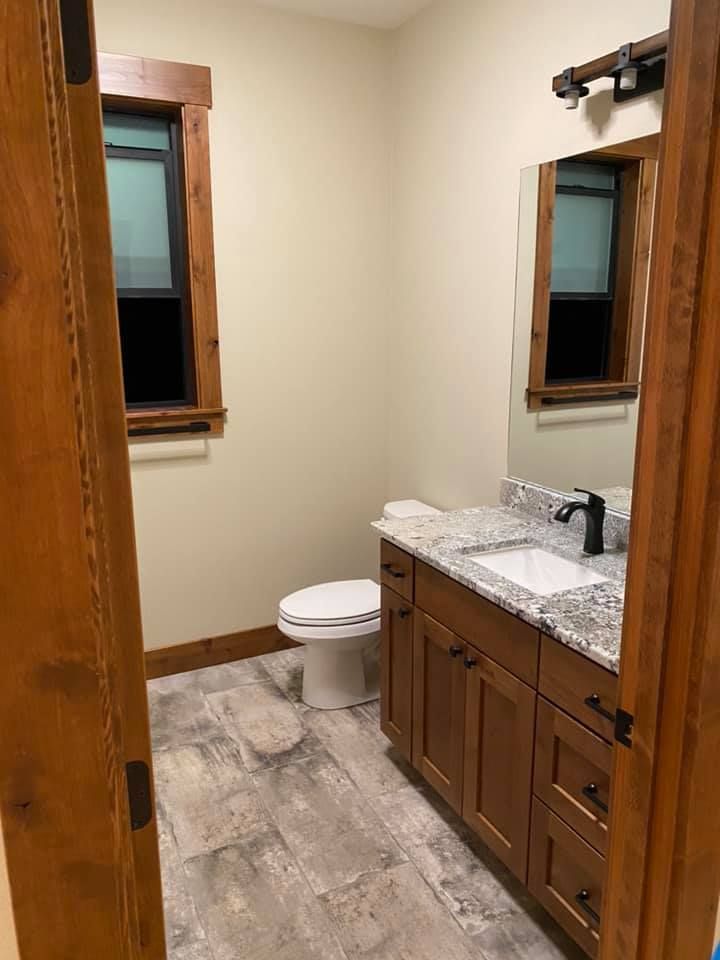 A bathroom with a toilet , sink and mirror.