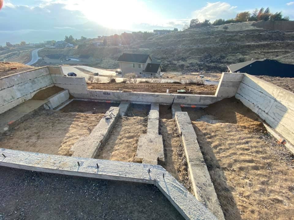 A large concrete structure is being built on top of a hill.