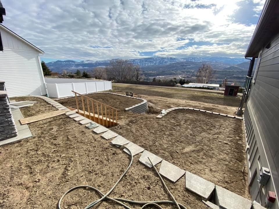 A hose is sitting in the dirt in front of a house.
