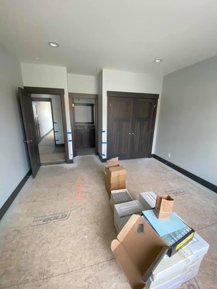 An empty room with boxes on the floor and a closet.