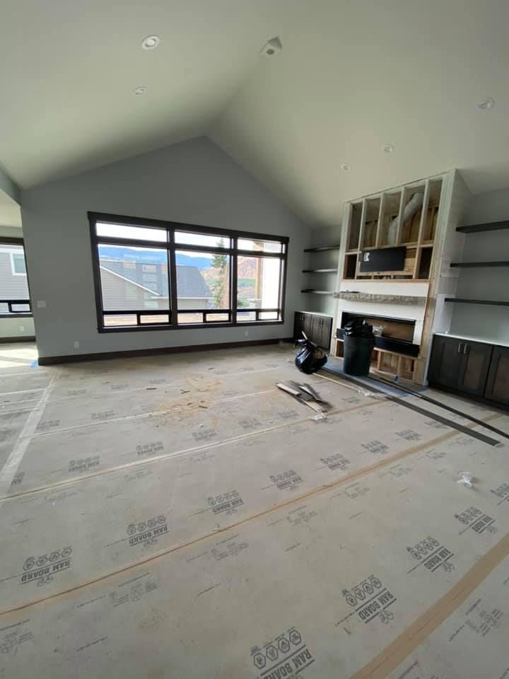An empty living room with a fireplace and a lot of windows.