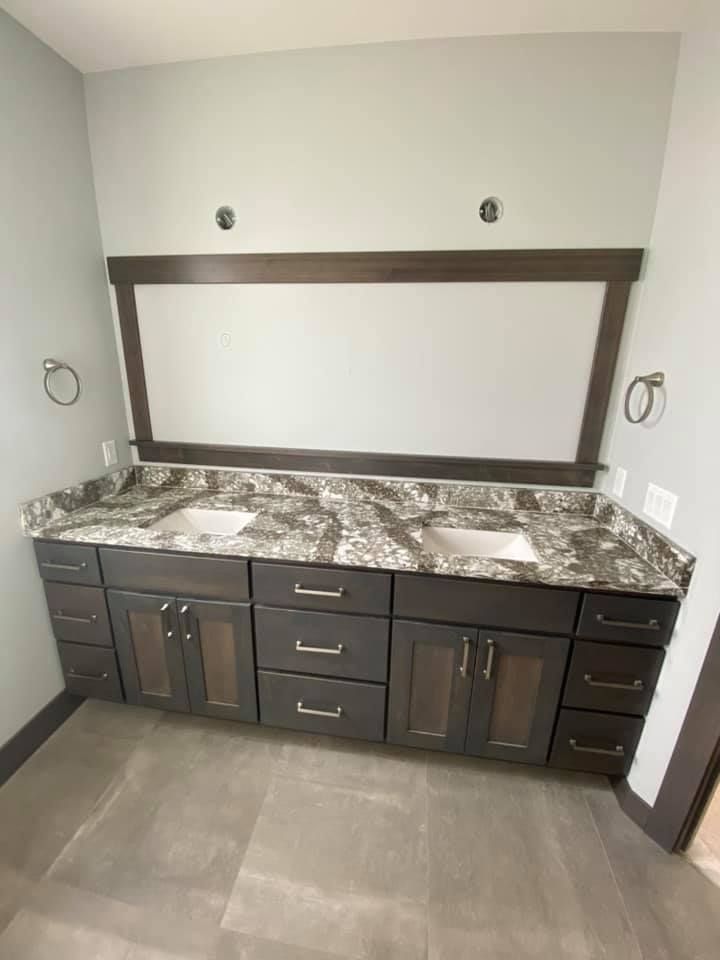 A bathroom with two sinks and a large mirror.