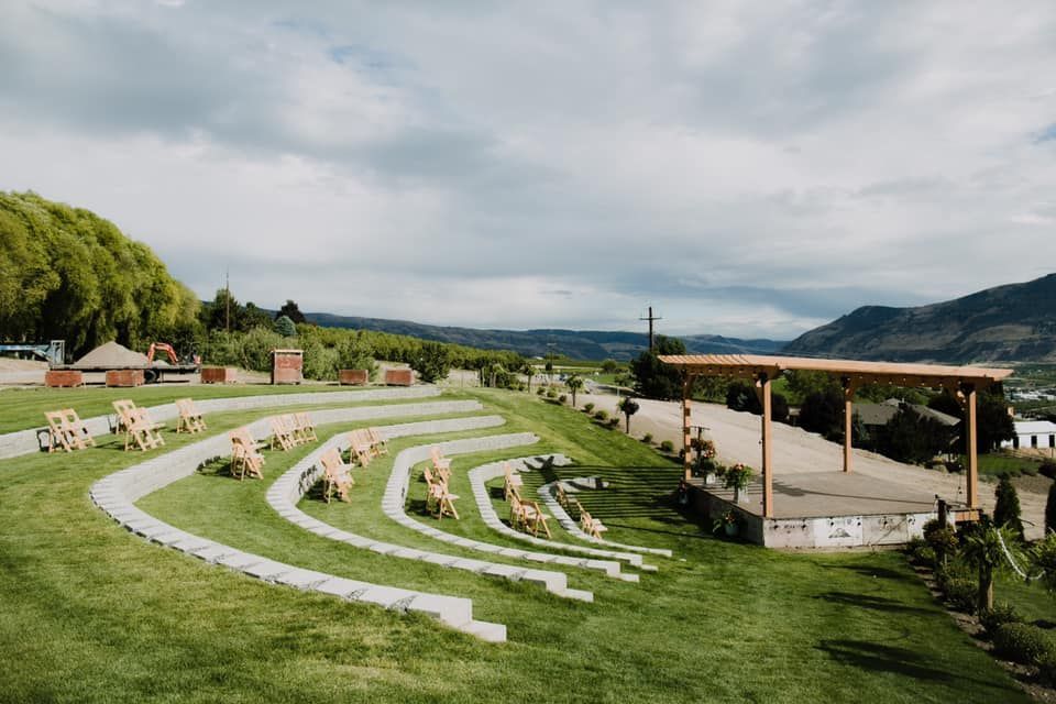 There is a large amphitheater in the middle of a lush green field.