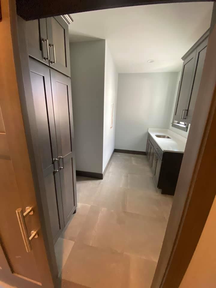A laundry room with lots of cabinets and a sink.