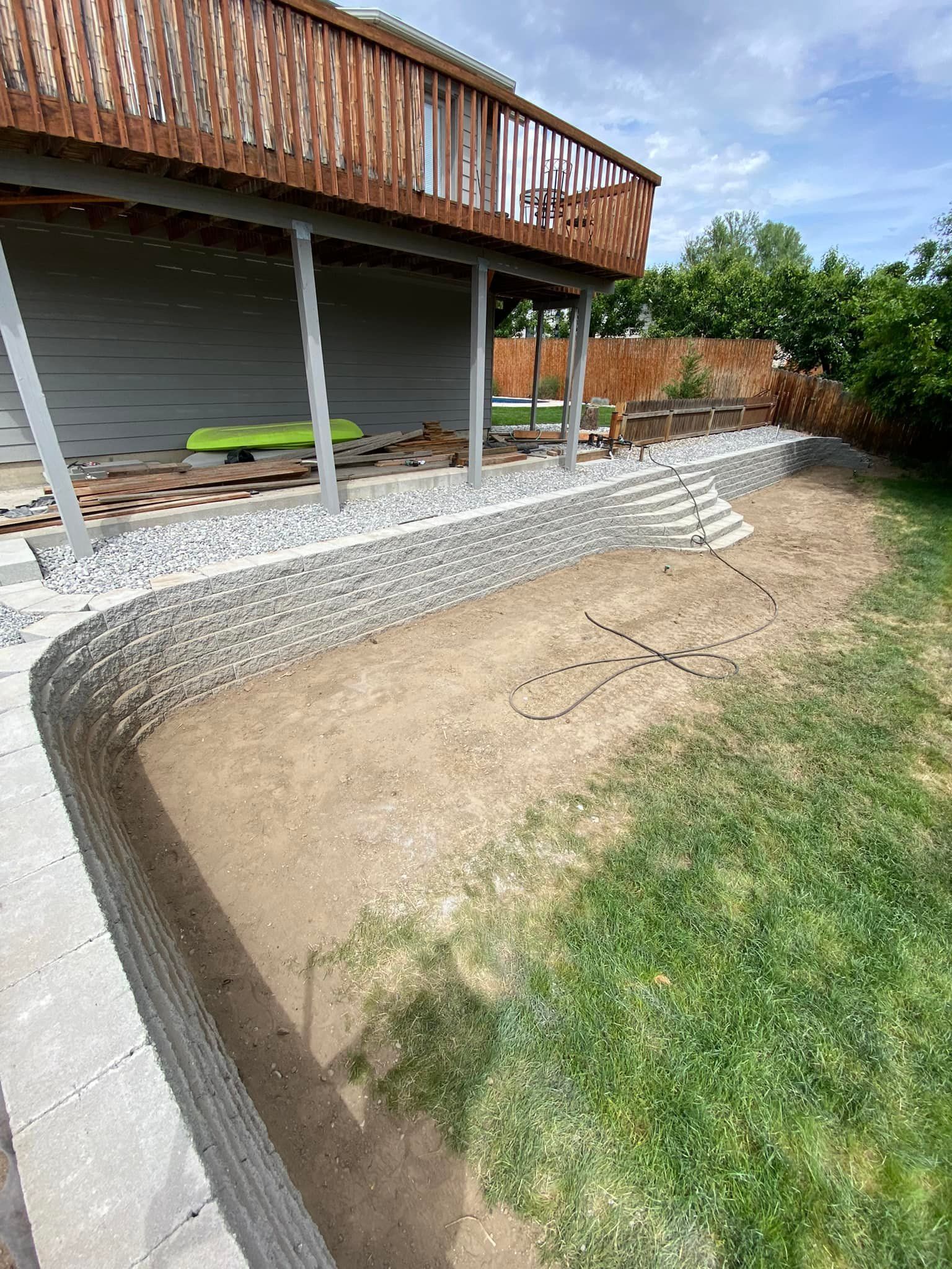 A concrete retaining wall is being built in front of a house.