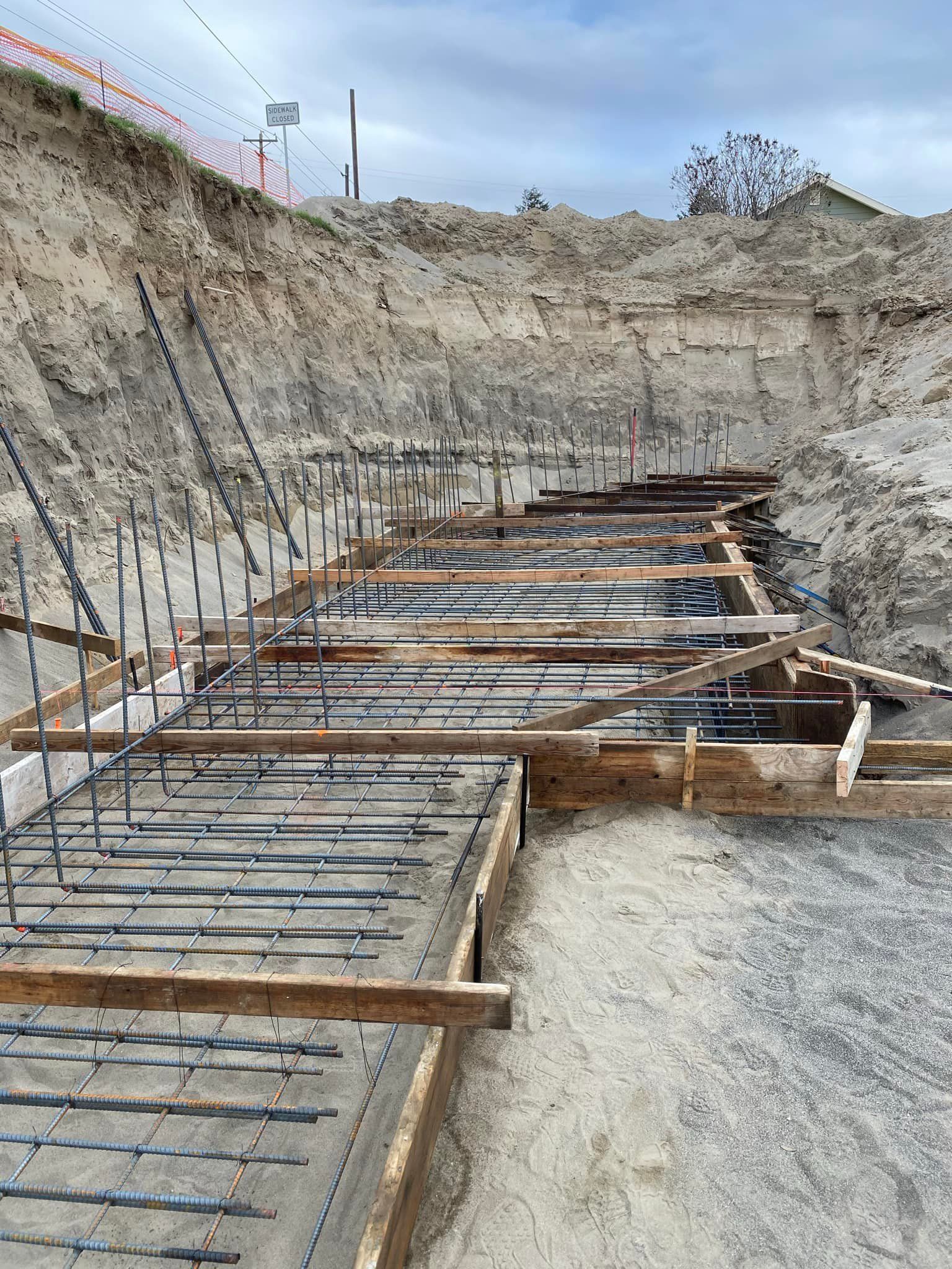 A concrete foundation is being built in a dirt field.