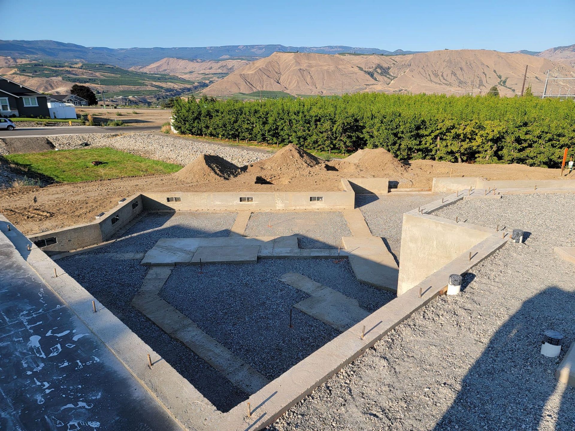 A large pile of gravel is sitting in the middle of a dirt field.
