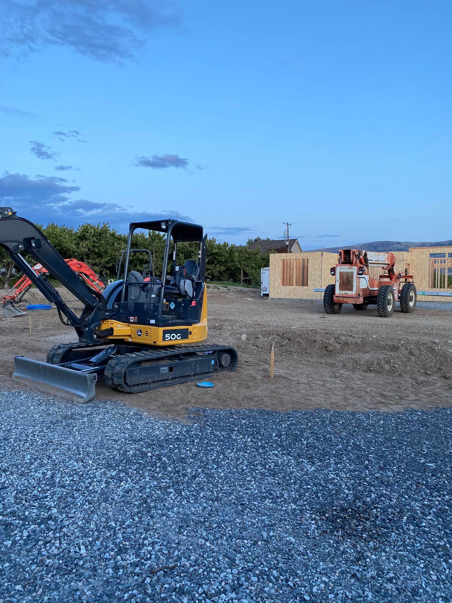 A bulldozer is sitting on top of a pile of gravel in a construction site.