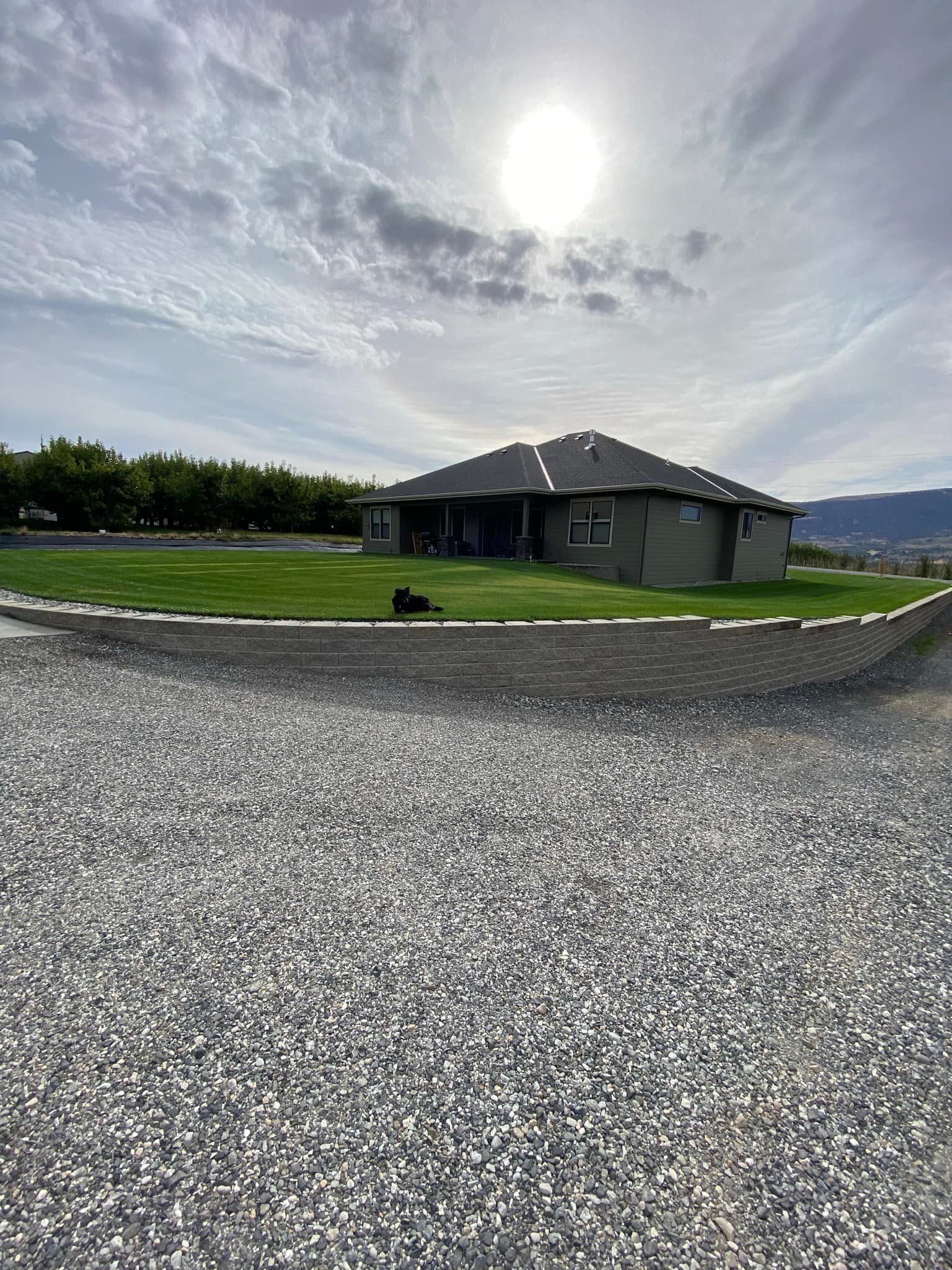 A large house with a gravel driveway in front of it.