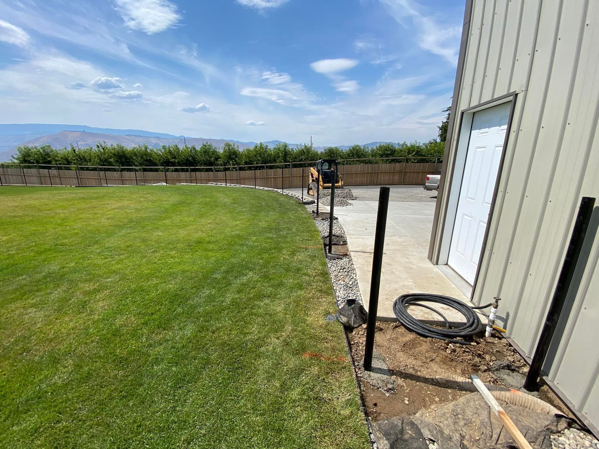 A fence is being built in the backyard of a house.