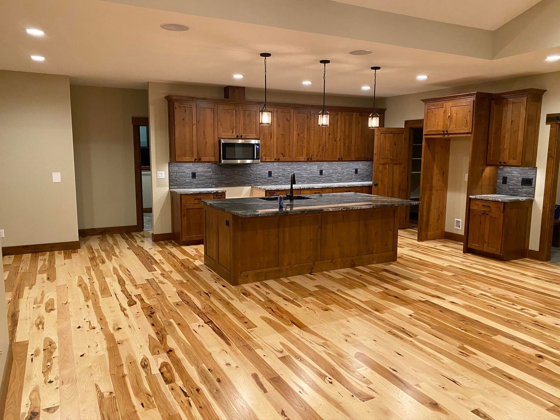 A kitchen with hardwood floors and stainless steel appliances.