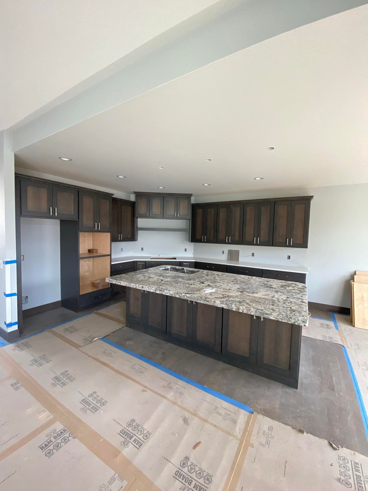 A kitchen under construction with a large island in the middle.