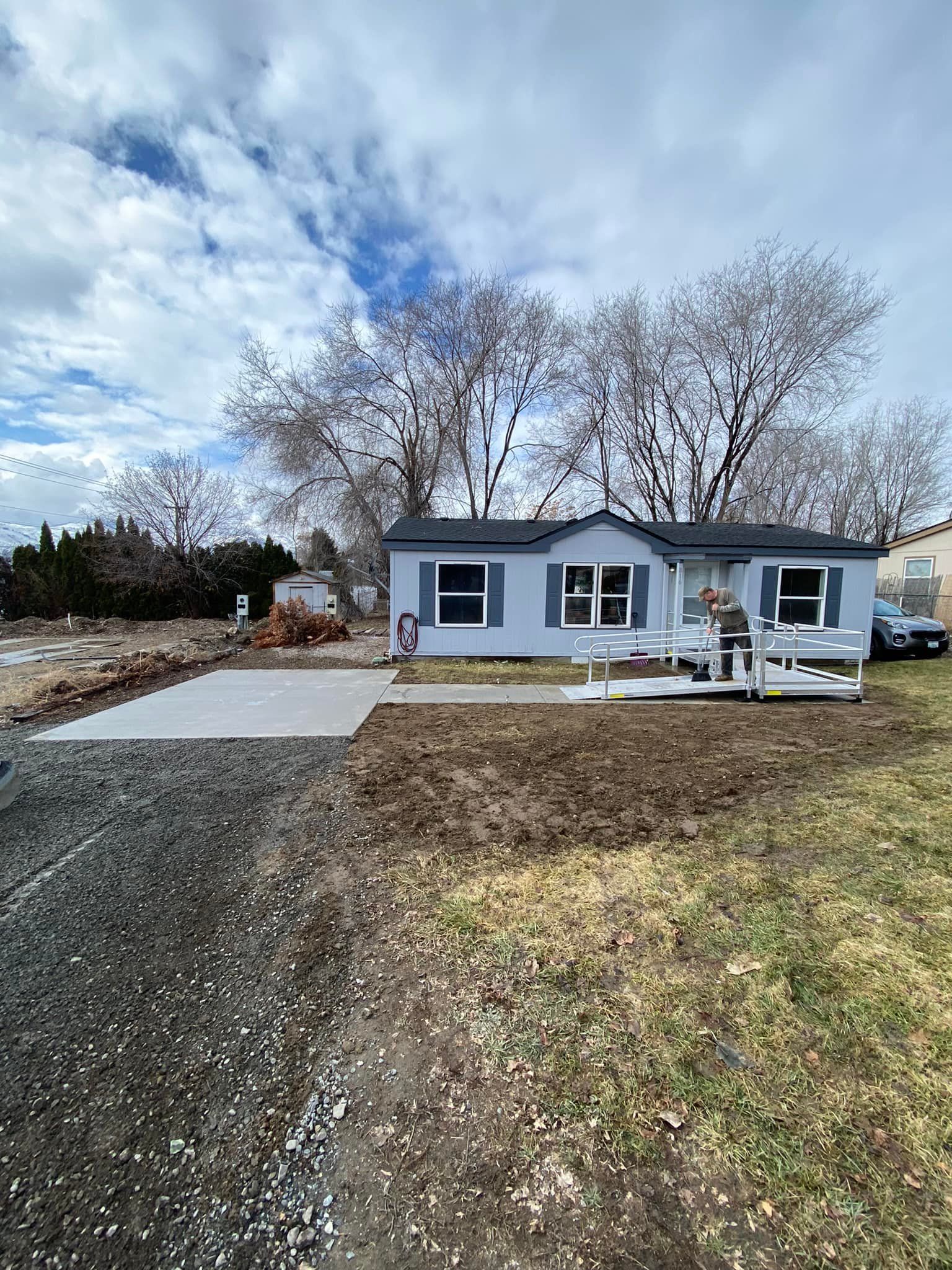 A mobile home is sitting in the middle of a grassy field.