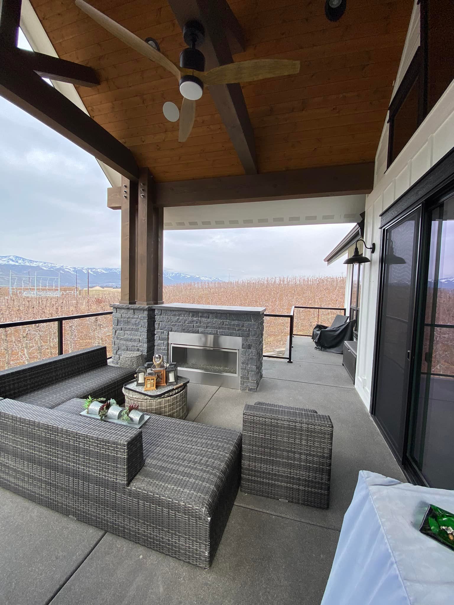 There is a patio with a fireplace and a ceiling fan.