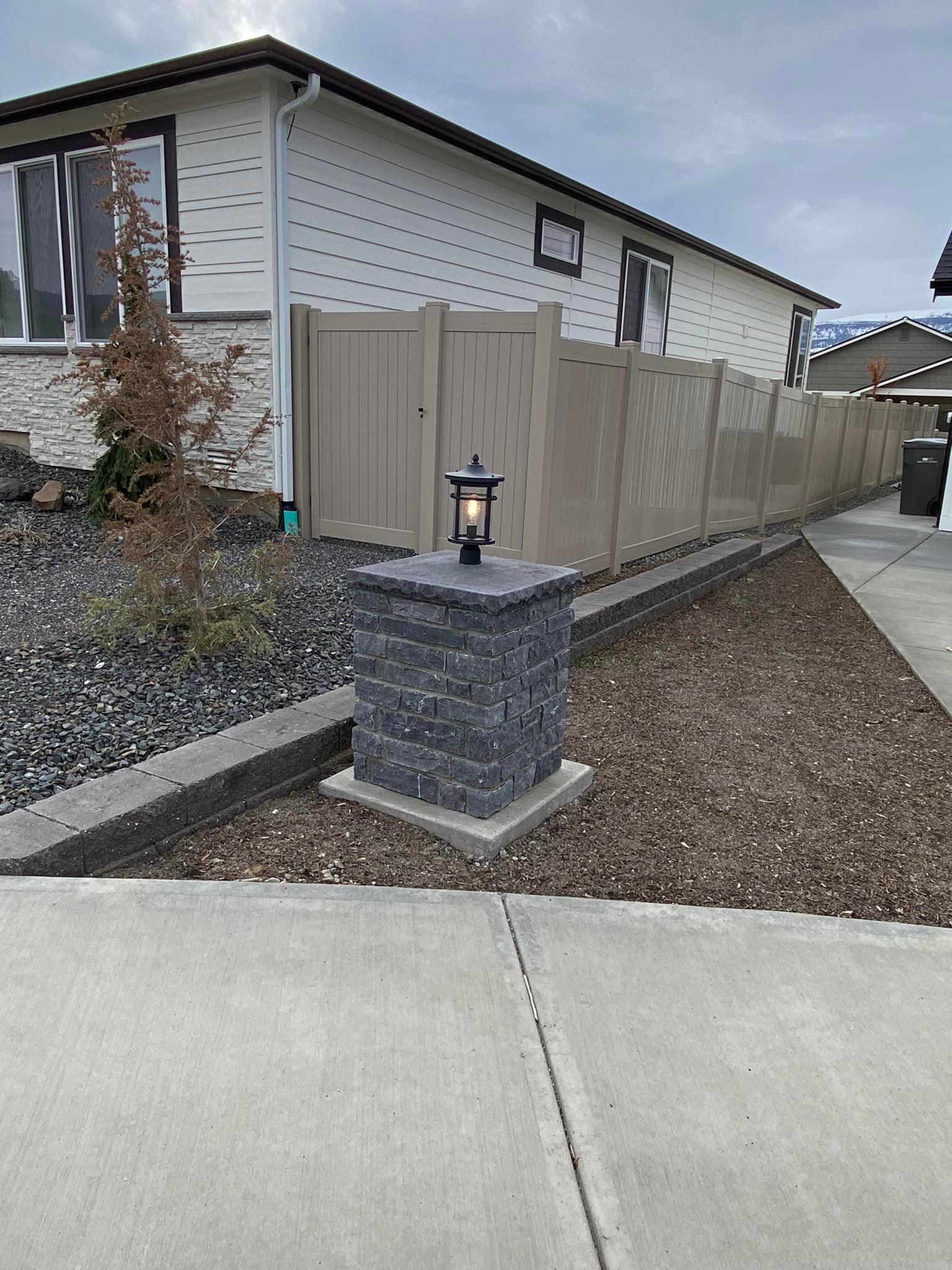 A house with a fence and a lamp post in front of it.