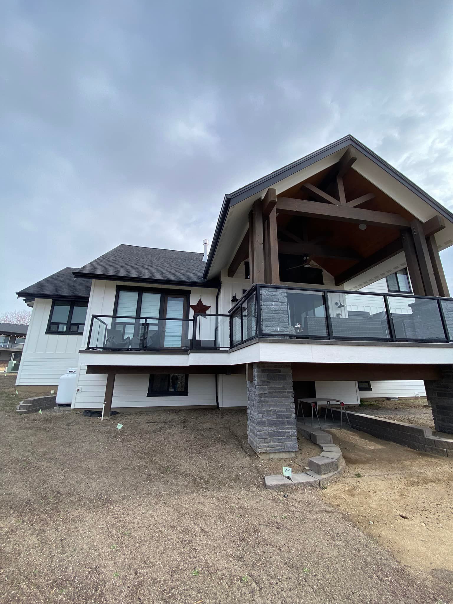 A large white house with a large deck and a covered porch.