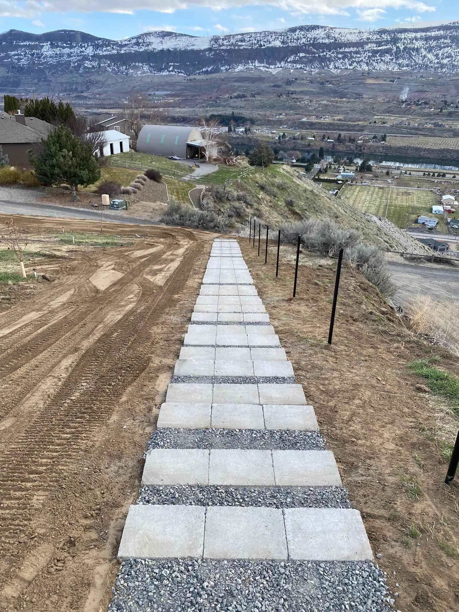 A staircase leading up to a hill with mountains in the background.