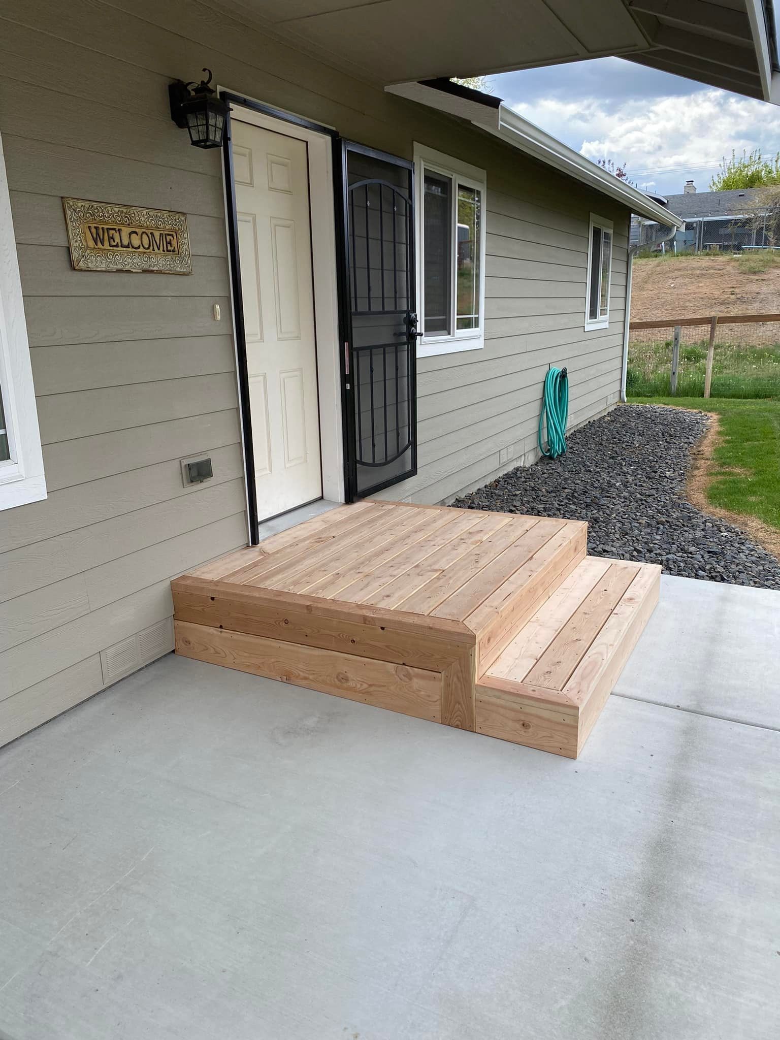 A house with a wooden porch and steps leading to the front door.