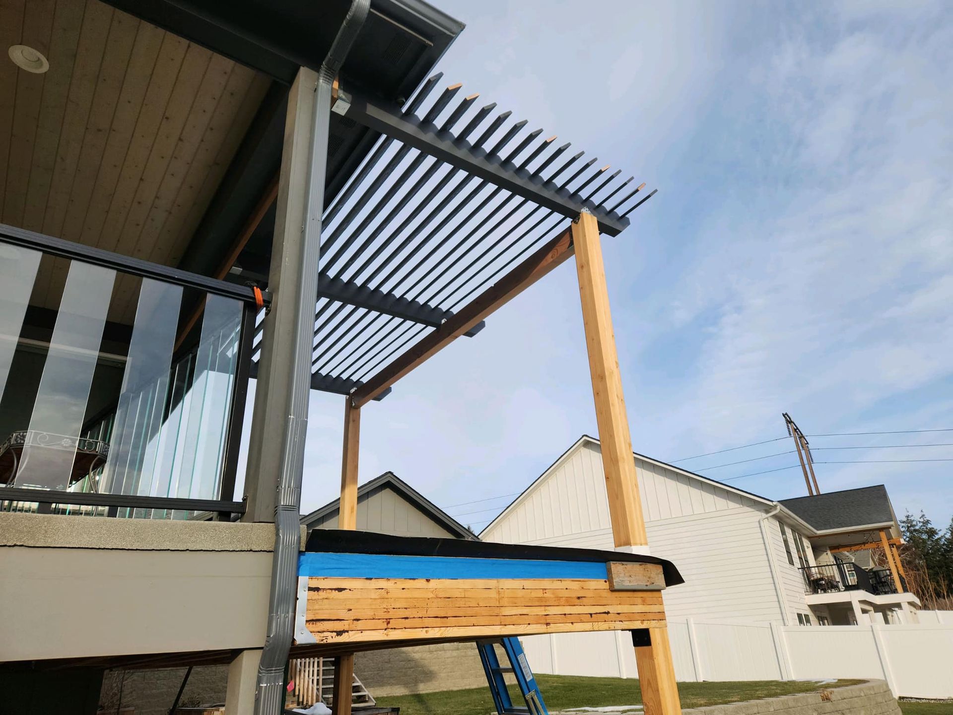 A pergola is being built on the side of a house.