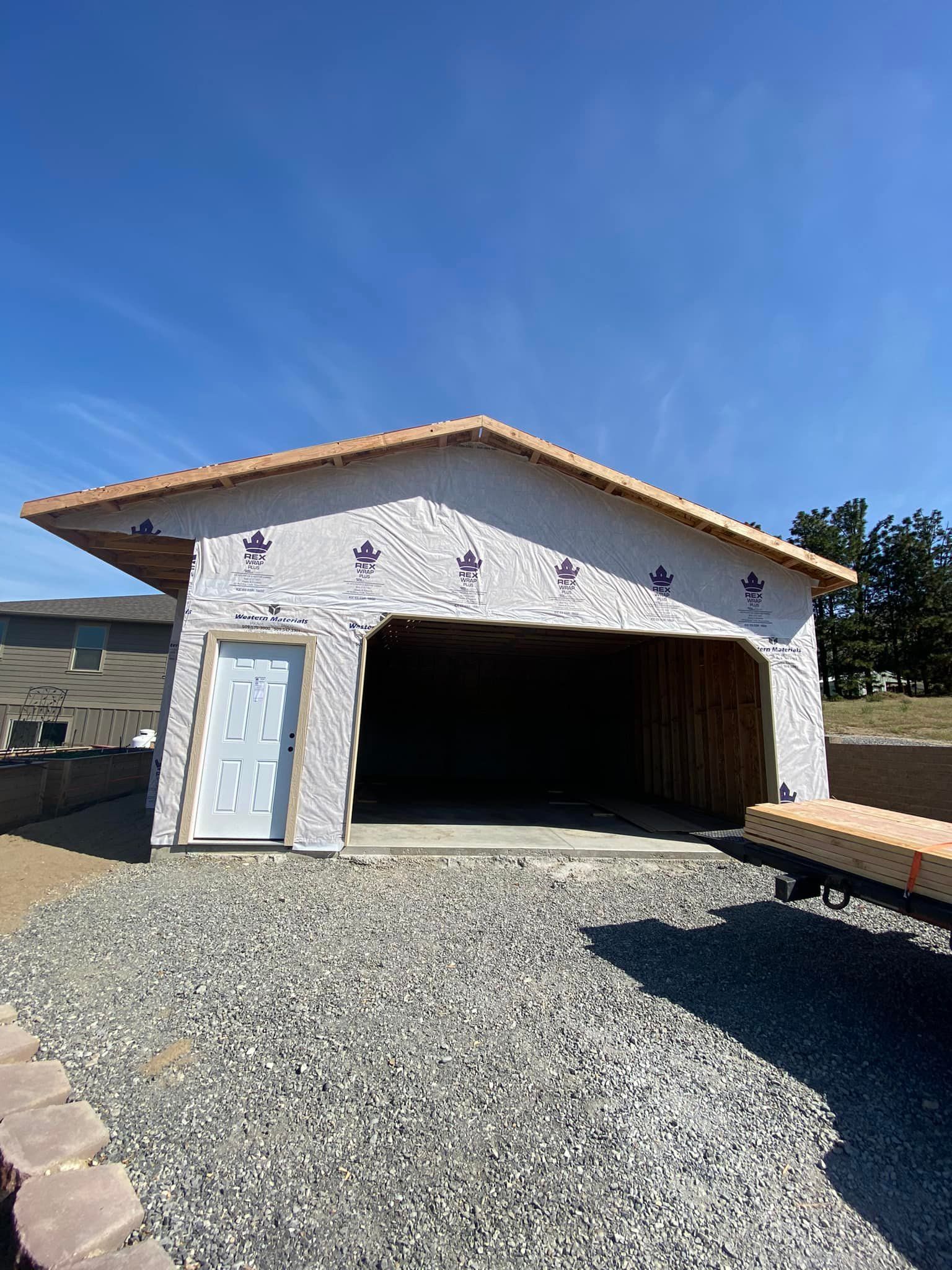 A garage under construction with a blue sky in the background.