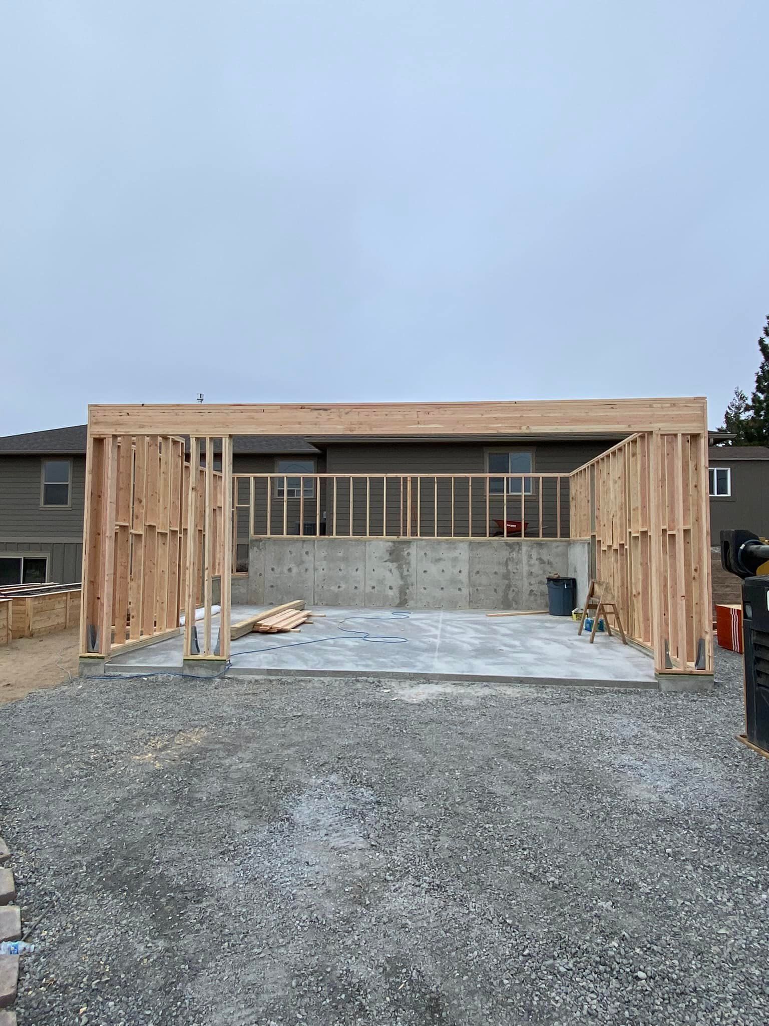 A garage is being built in the backyard of a house.