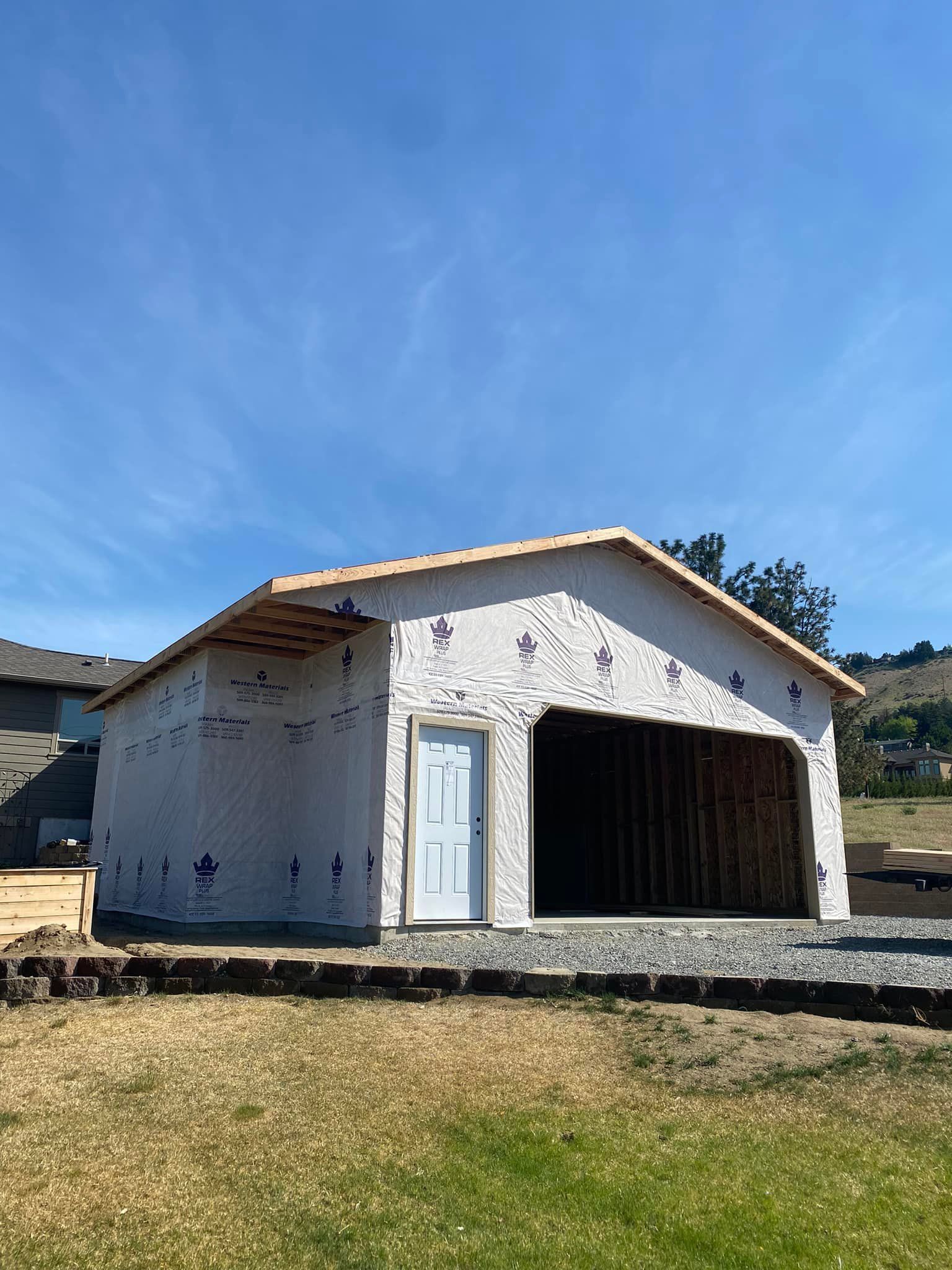 A garage is being built in the middle of a grassy field.