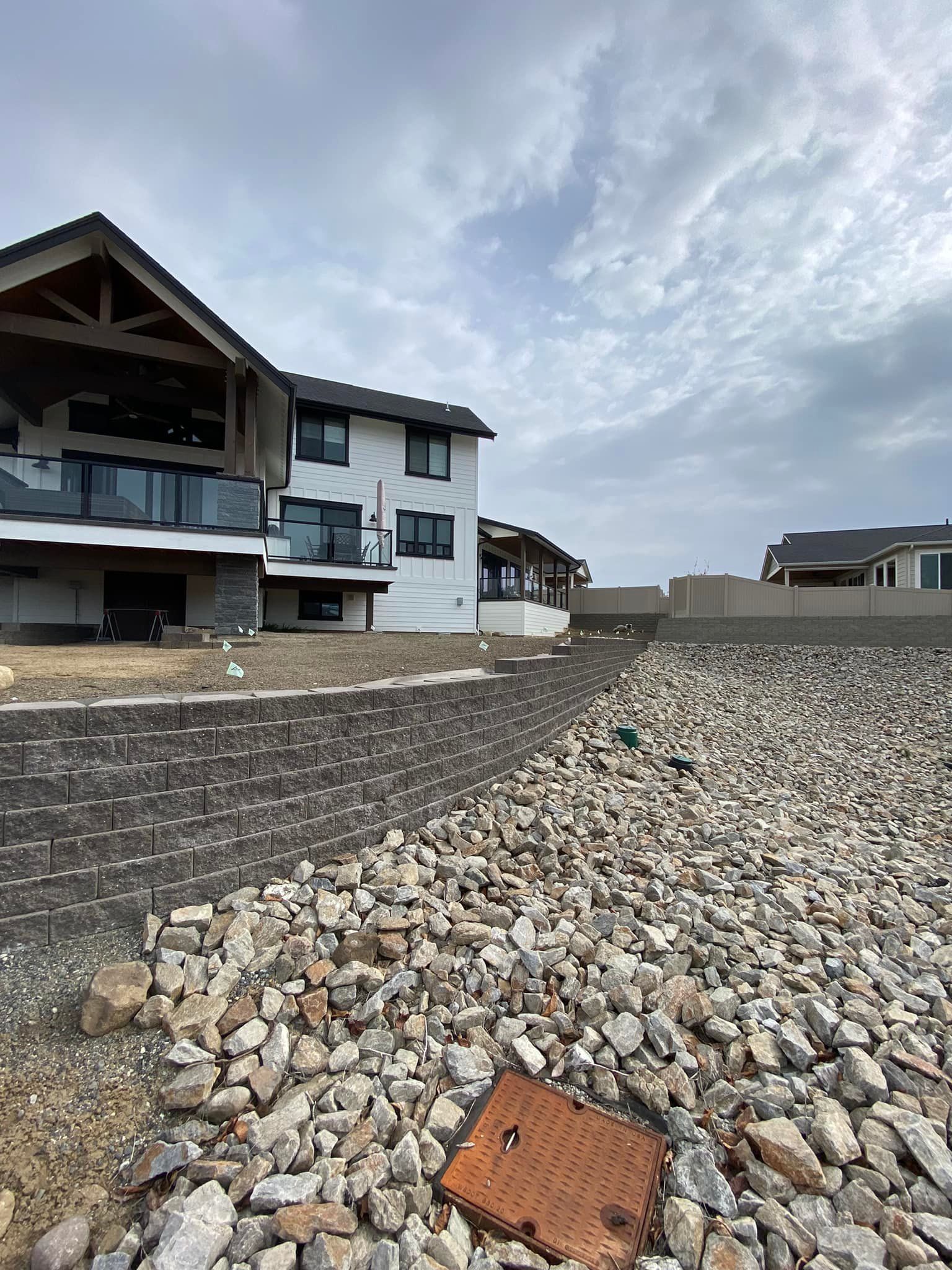 A large house is sitting on top of a pile of rocks.