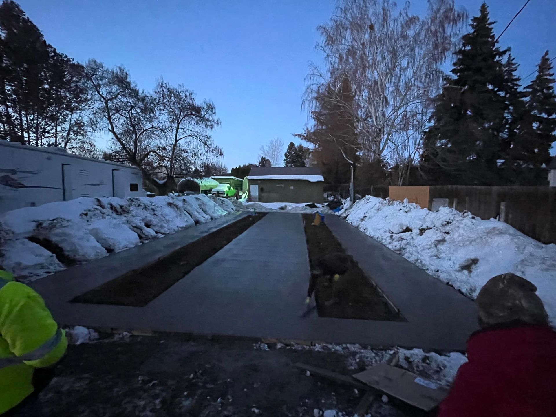 A man in a yellow jacket is standing in the snow