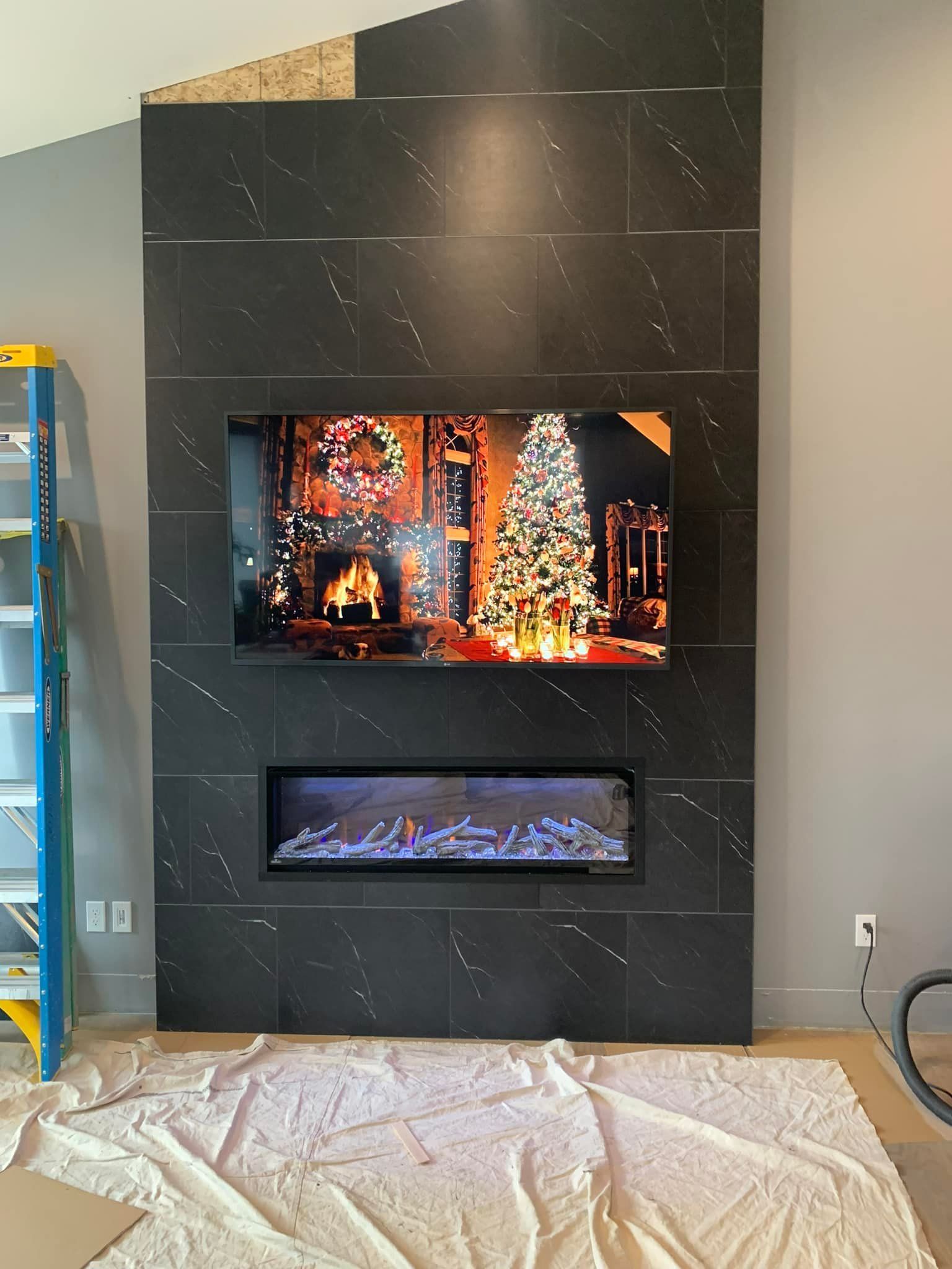 A living room with a fireplace and a flat screen tv on the wall.